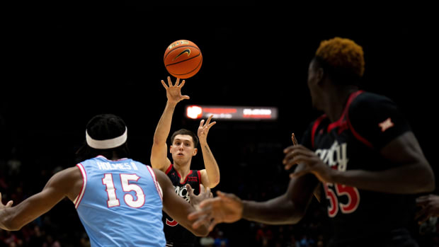 Cincinnati Bearcats guard CJ Fredrick (5) passes it to Cincinnati Bearcats forward Aziz Bandaogo (55) for a dunk in the first half of the NCAA men's basketball game between the Dayton Flyers and Cincinnati Bearcats at Heritage Bank Center in Cincinnati on Saturday, Dec. 16, 2023.  